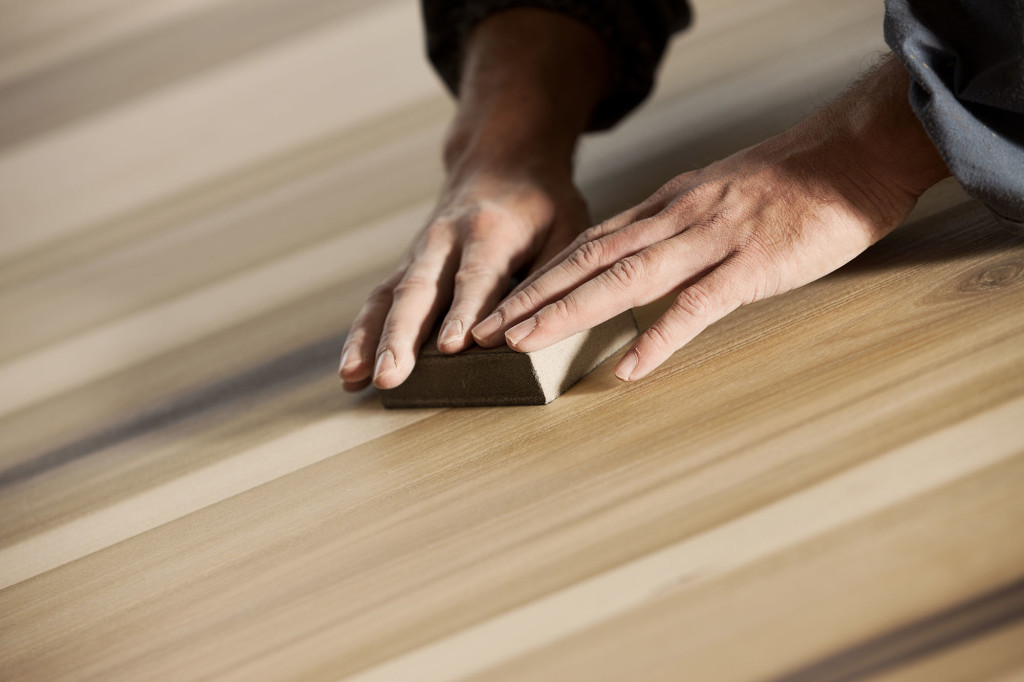 A Man Sanding the SUrface of Wood