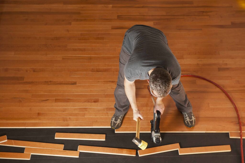 A Man Installing Solid Hardwood for Flooring