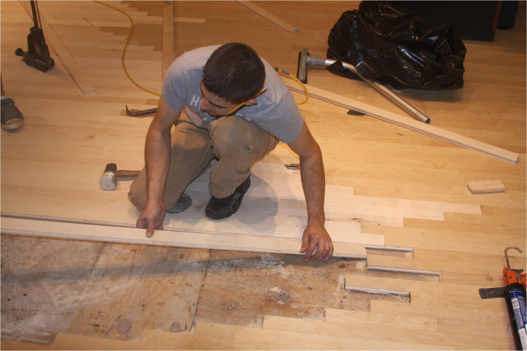 A Man Installing Wood Panels on the Floor