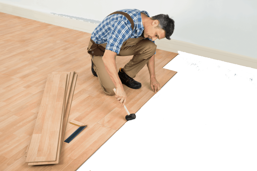 A Man Hammering a Wood Floor Panels