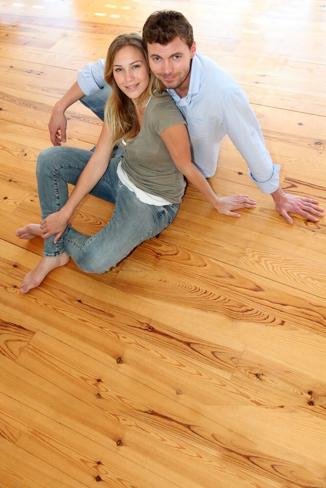 a couple sitting on the floor and looking at camera